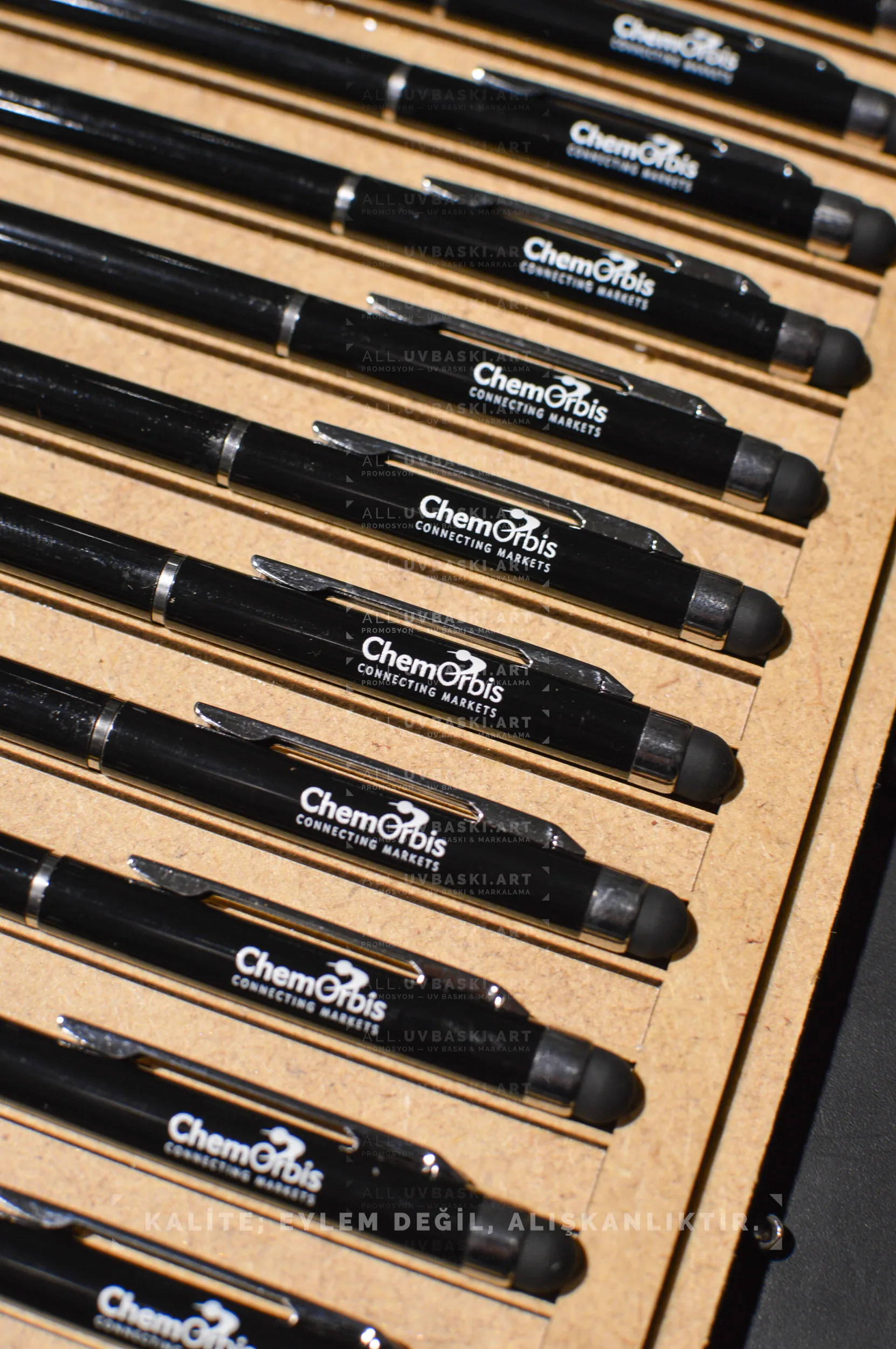 Siyah metal t&uuml;kenmez kalem &uuml;zerinde beyaz UV baskı ile ince yazı.