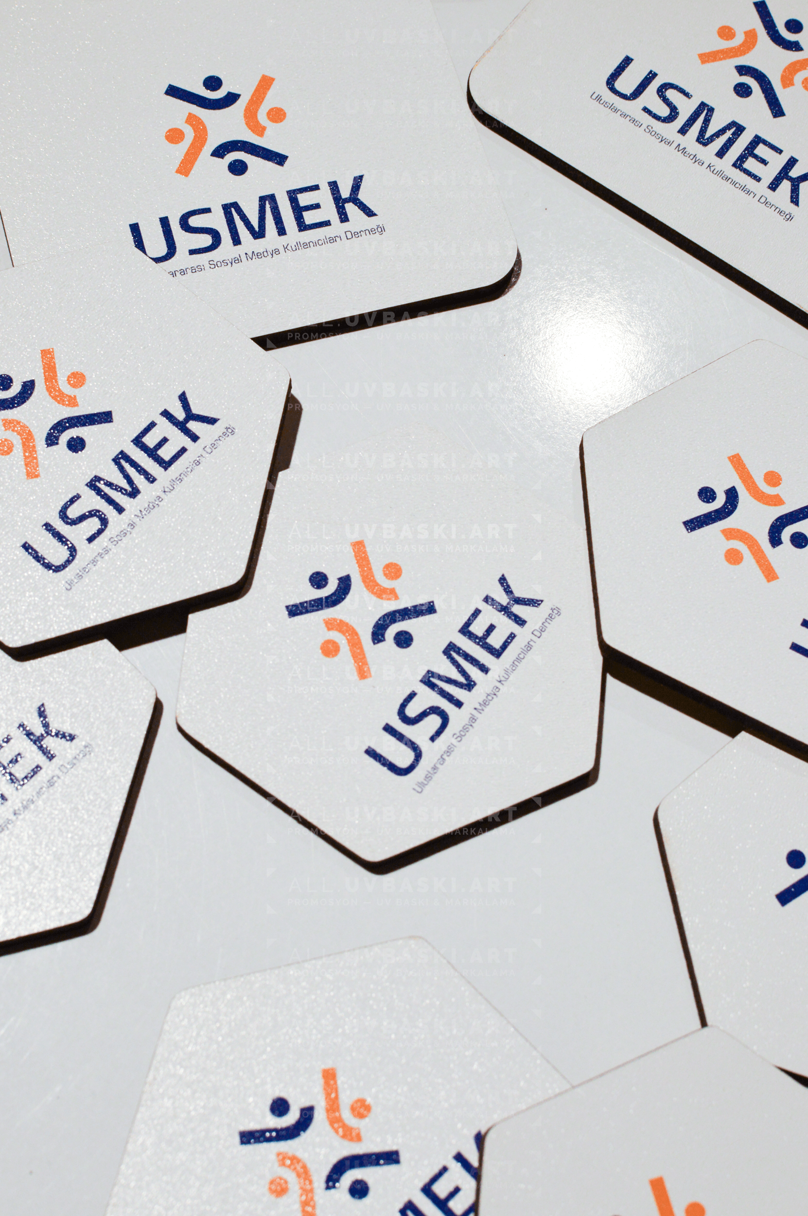 Beyaz MDF üzerine UV baskılı USMEK logosu yer alan buzdolabı magneti.