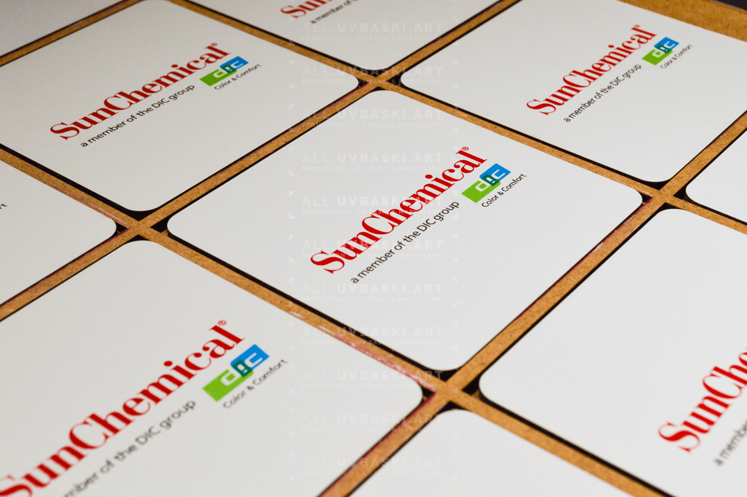 Beyaz MDF bardak altlığı üzerine UV baskılı renkli Sun Chemical logosu.