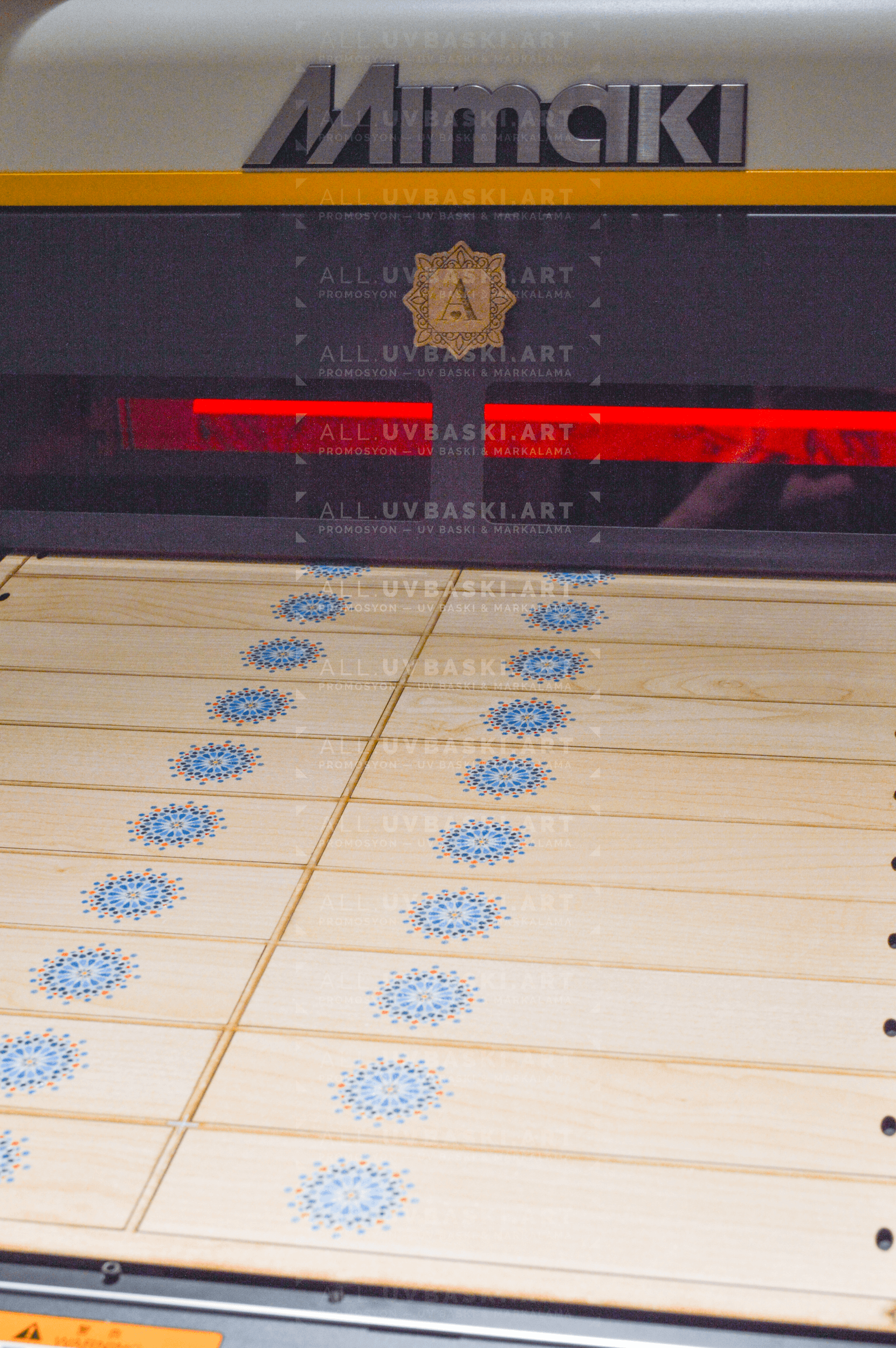 Huş desenli MDF üzerinde rengarenk UV baskılı logo yakın çekim detayı.