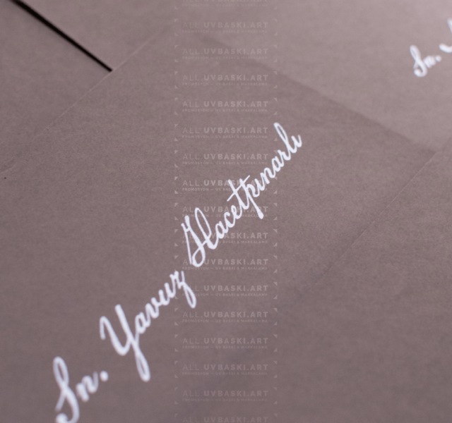 Siyah zarf üzerine beyaz yazı kaligrafi ile yazılmış davetli ismi.