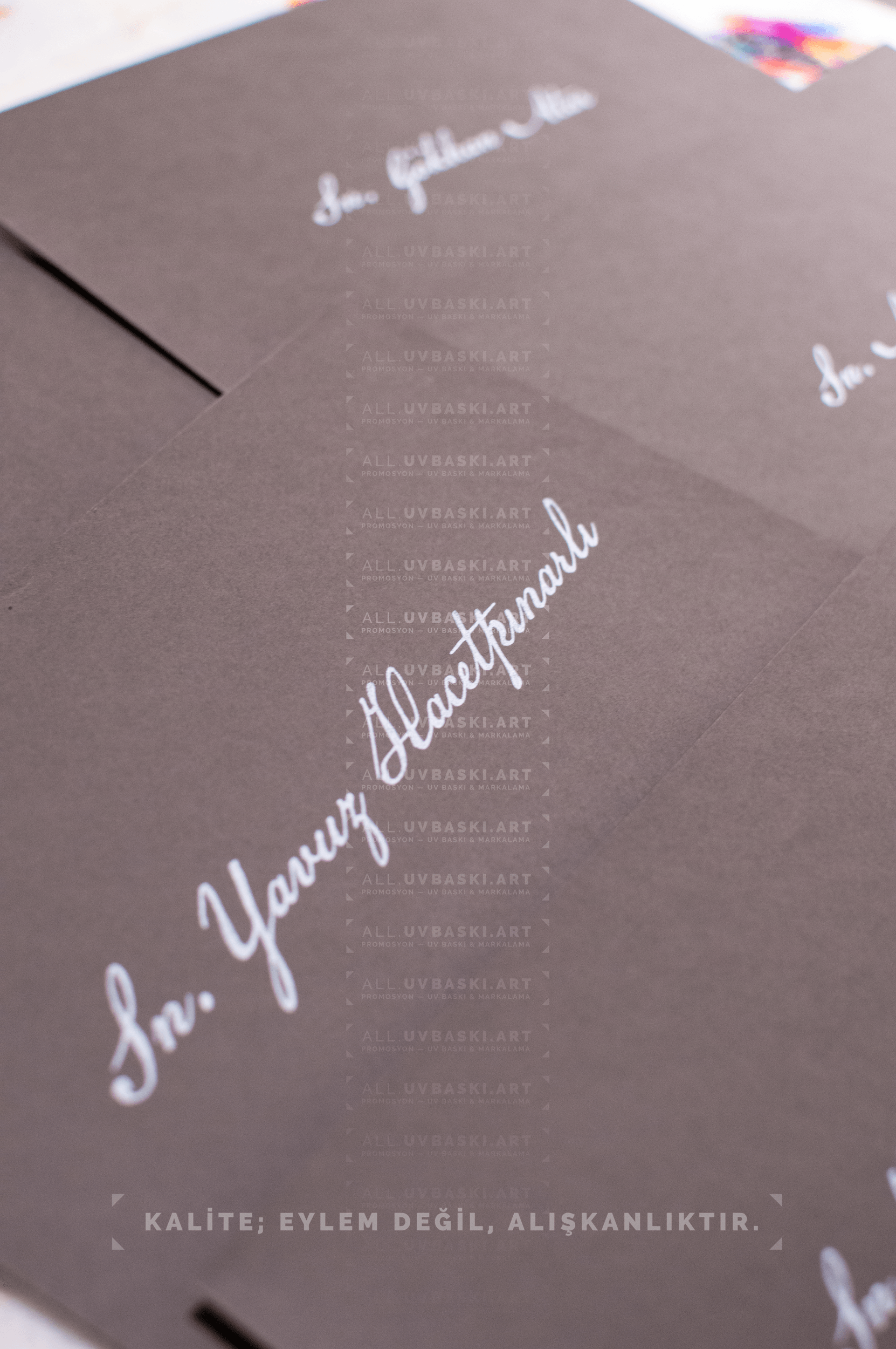 Siyah zarf üzerine beyaz yazı kaligrafi ile yazılmış davetli ismi.