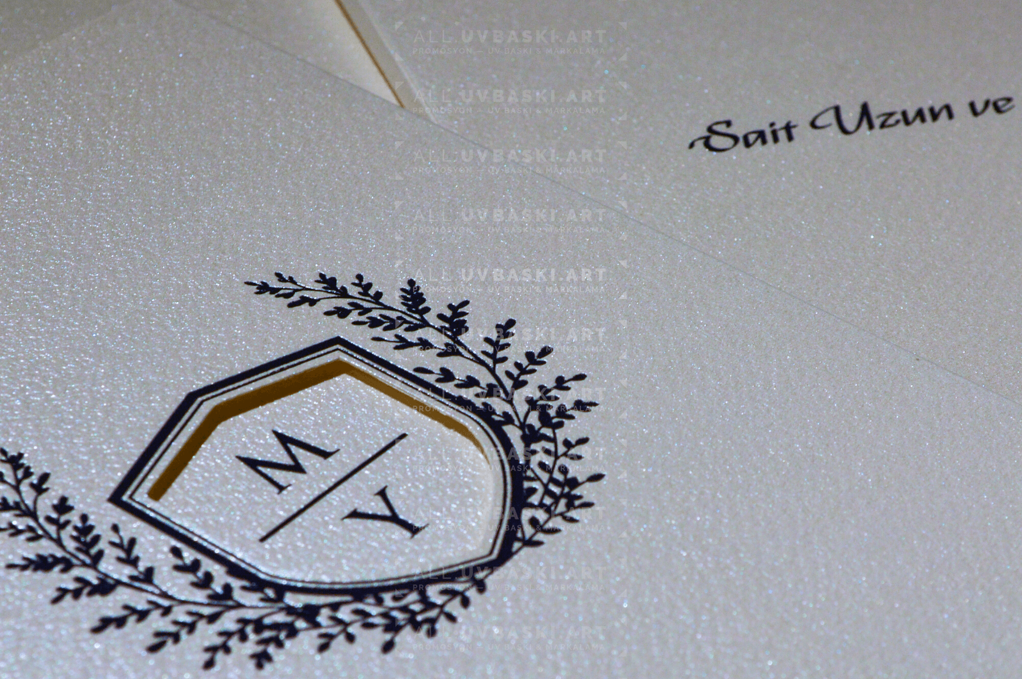 Krem davetiye zarfı üzerine siyah kaligrafi yazı ile isim yazılmış hali.