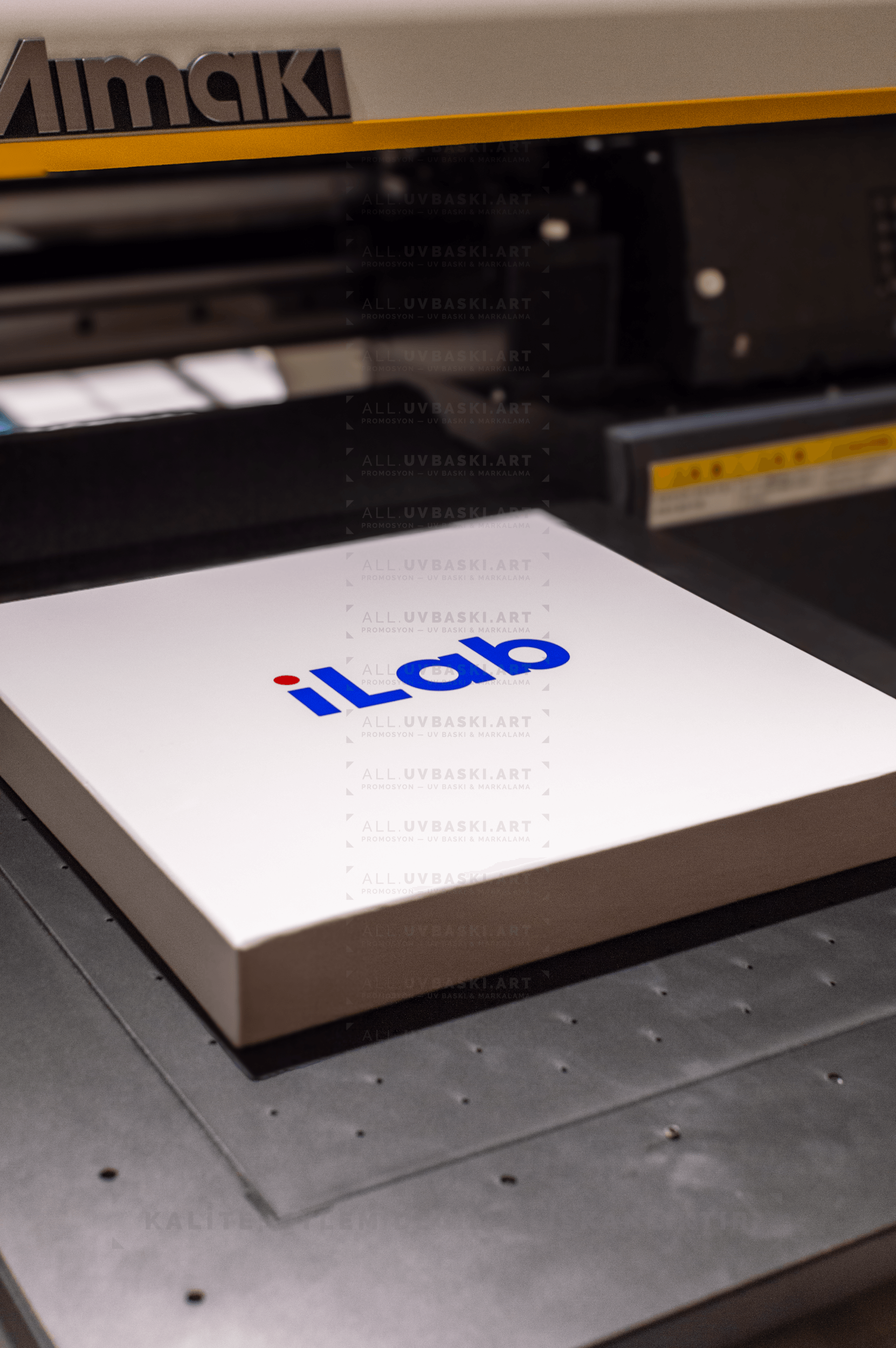 Beyaz sıvama kutu kapağı üzerine mavi renkli şirket logosu UV baskı örneği.