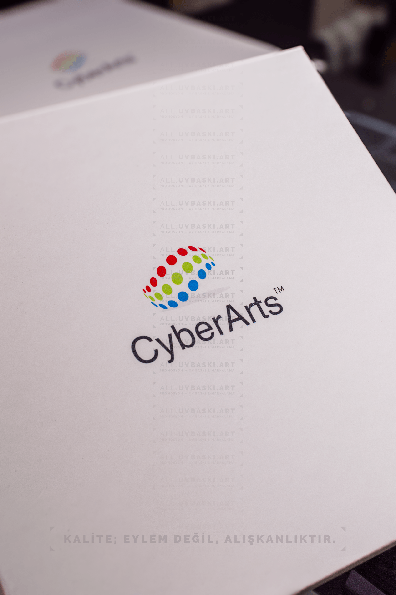 Beyaz kutu kapağı üzerine küçük ve minimalist bir ikonun UV baskısı.