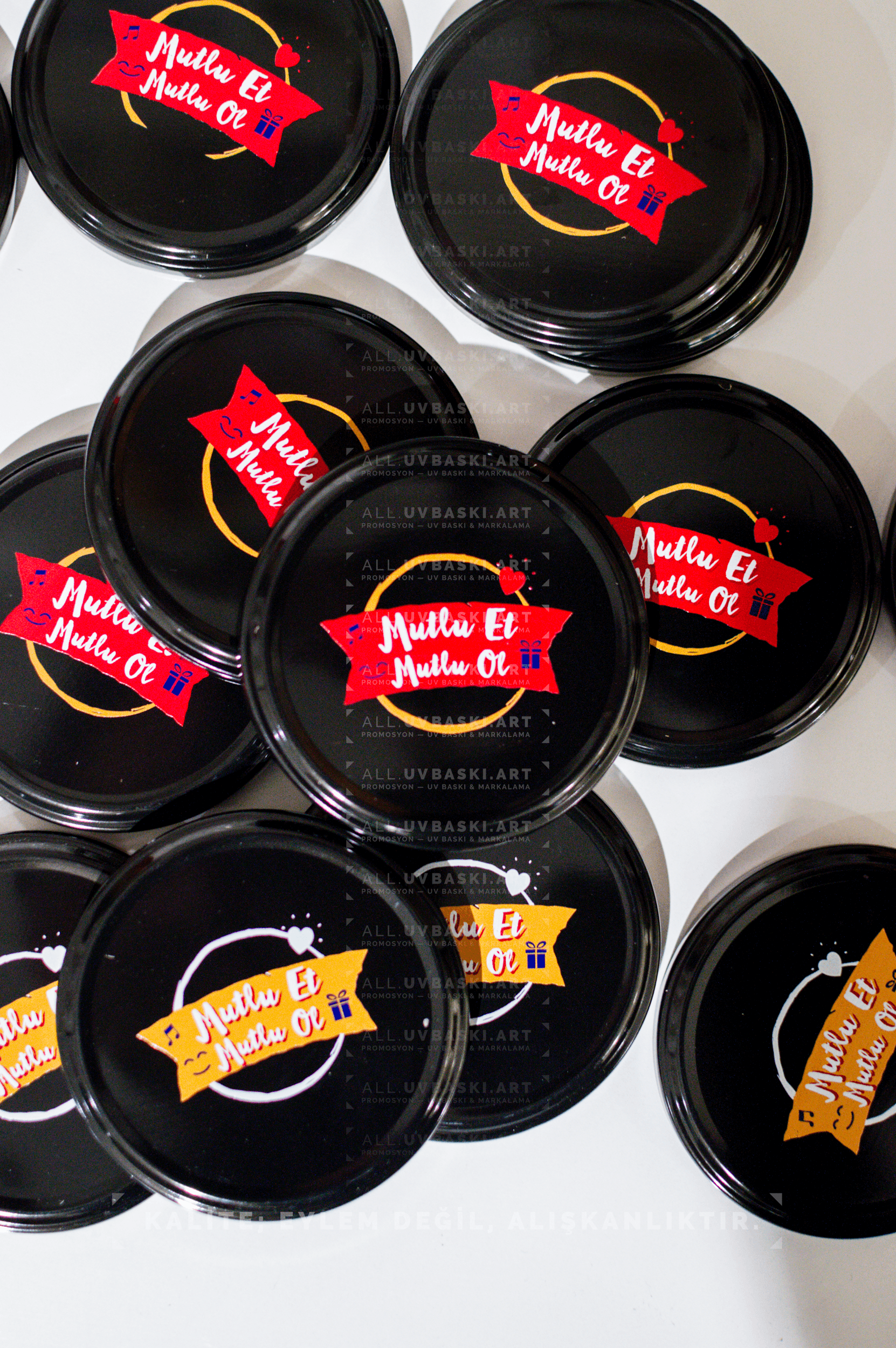 Siyah kavanoz kapağı üzerine Ülker Mutlu et, mutlu ol motto logosu, UV baskı örneği.