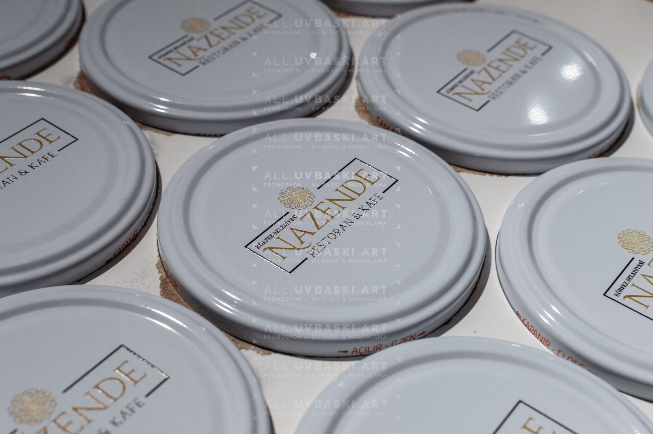 Beyaz kavanoz kapağı üzerine Nazende logosu, UV baskı örneği.