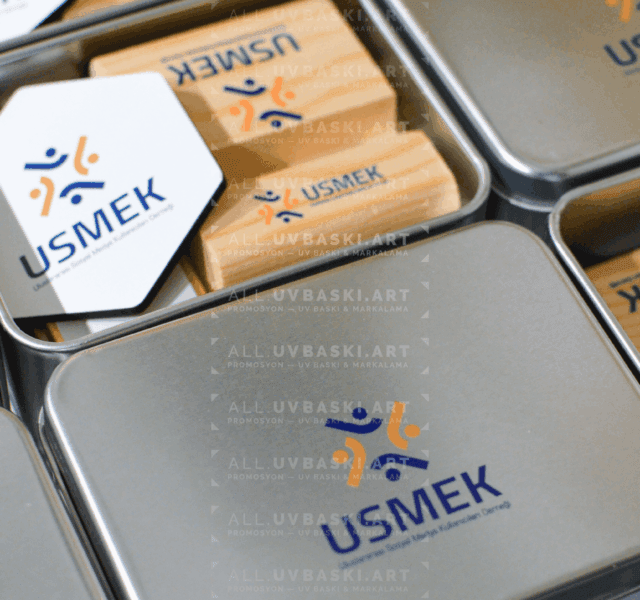 Mavi/gri teknoloji firması logolu, UV baskılı metal kurumsal hediye seti kutusu; içinde kahve, açacak, çikolata, magnet, telefon standı.