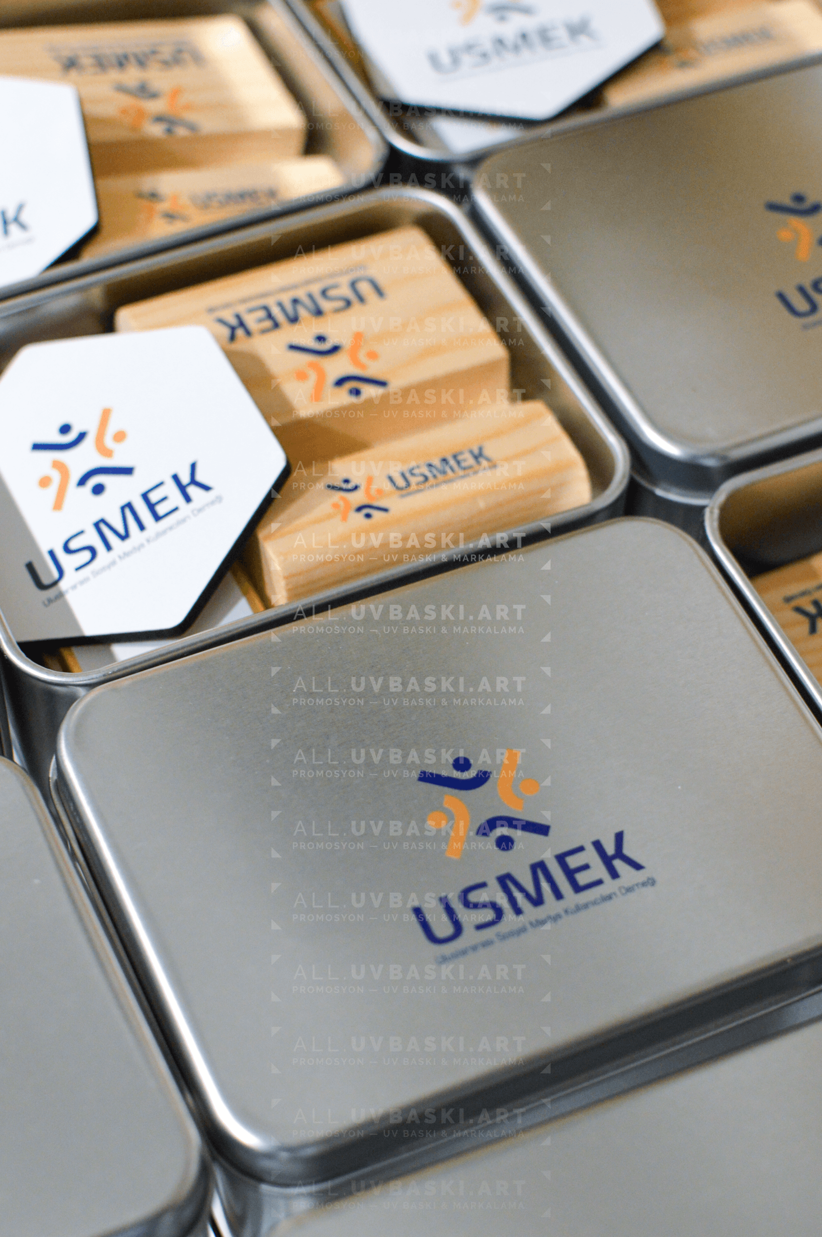 Mavi/gri teknoloji firması logolu, UV baskılı metal kurumsal hediye seti kutusu; içinde kahve, açacak, çikolata, magnet, telefon standı.