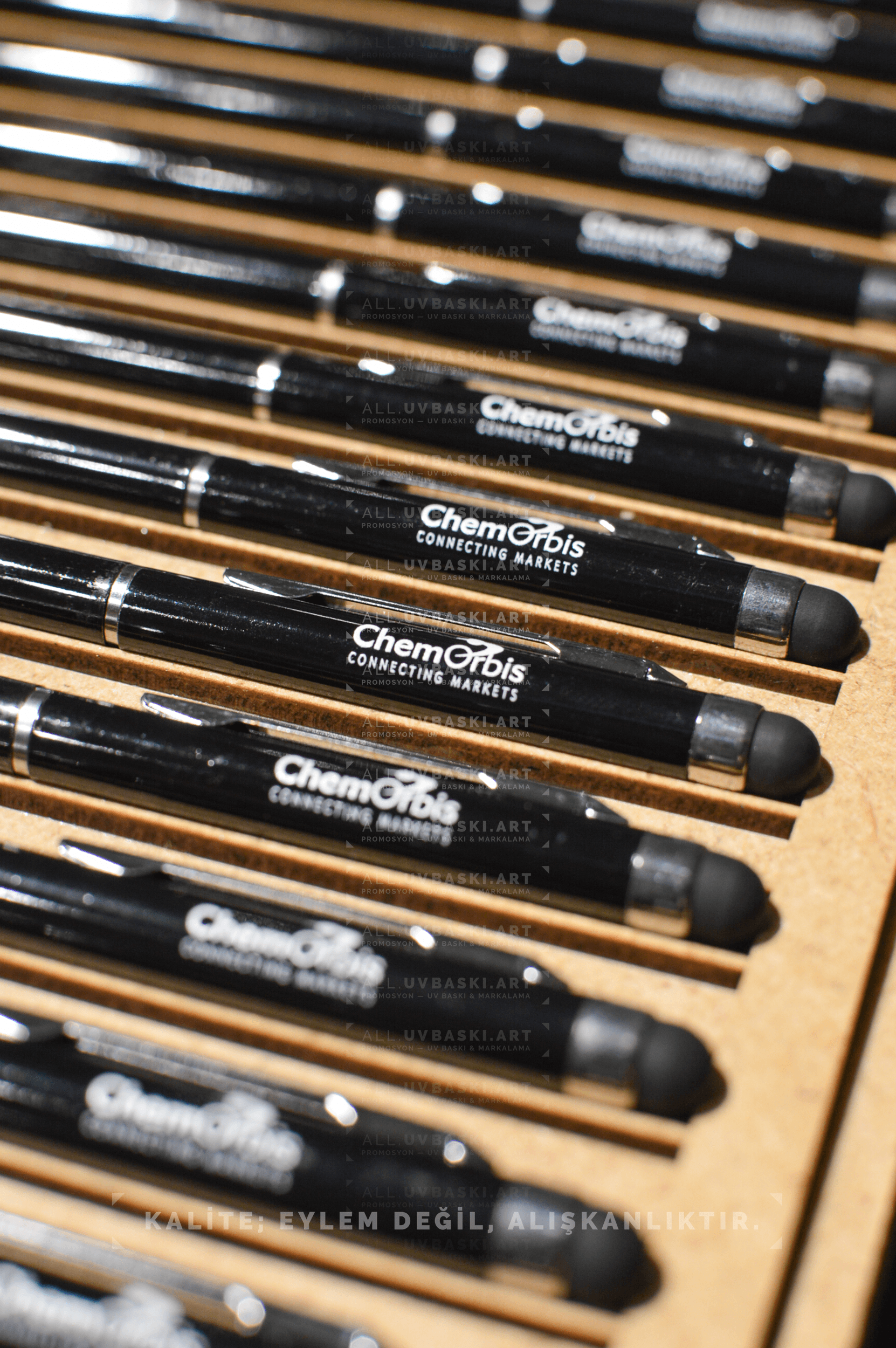 Siyah metal tükenmez kalem üzerinde beyaz UV baskı ile işlenmiş logo.