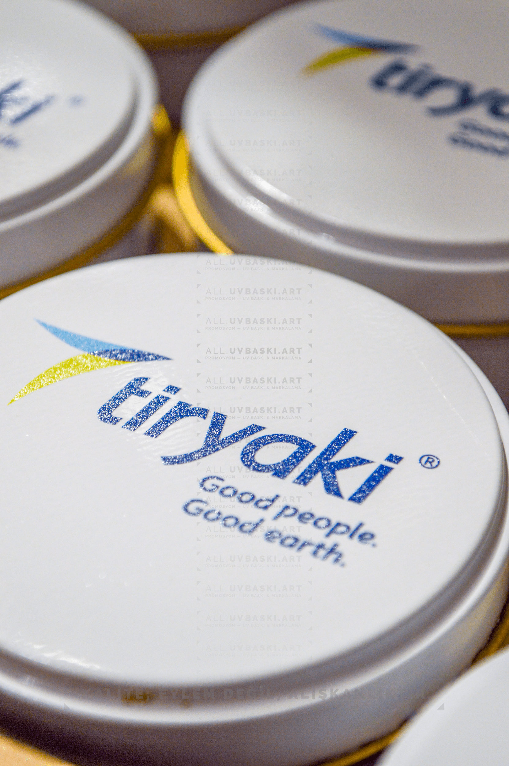 Beyaz yuvarlak mum kutusu üzerine UV baskılı Tiryaki marka logosu.